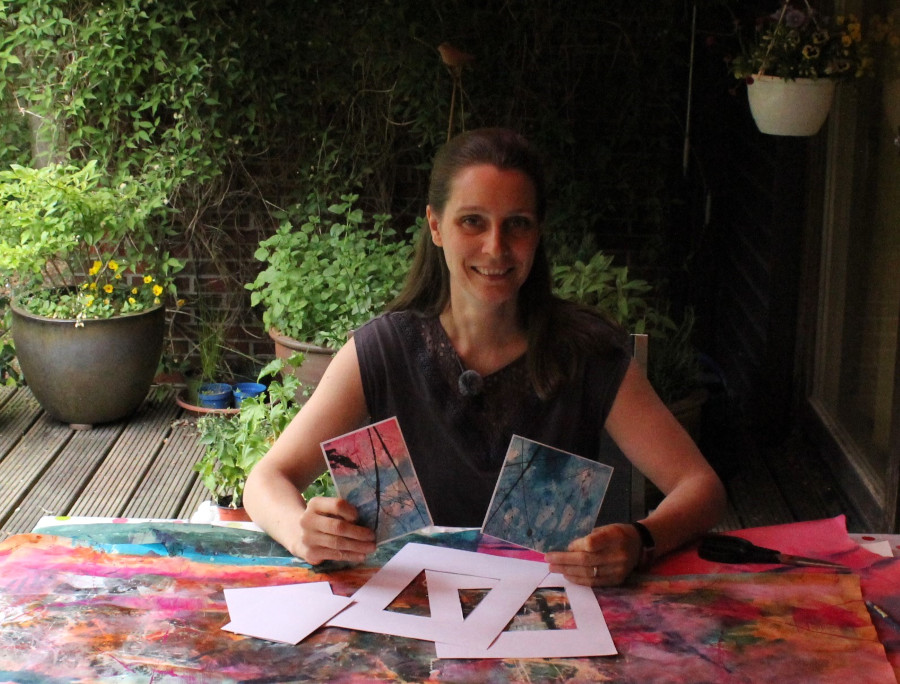 Anna Budin holding two hand-made post cards.